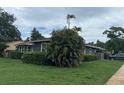 Well-maintained single story home with green lawn and mature foliage at 1601 14Th N St, St Petersburg, FL 33704