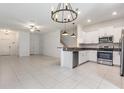 Open-concept living space with white kitchen cabinets and stainless steel appliances at 17482 Nectar Flume Dr, Land O Lakes, FL 34638