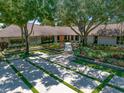 Stunning ranch-style home with a meticulously landscaped front yard and a grand driveway with grass accents at 1835 Alicia Way, Clearwater, FL 33764