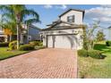 Two-story home showing the brick driveway, two-car garage, and manicured bushes in the front yard at 19656 Long Lake Ranch Blvd, Lutz, FL 33558