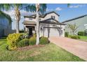 Attractive two-story home with a brick-paved driveway, two-car garage, and lush, tropical landscaping at 19656 Long Lake Ranch Blvd, Lutz, FL 33558