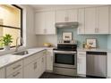 Modern kitchen featuring stainless steel appliances, white cabinets, and beautiful countertops at 2621 Cove Cay Dr # 206, Clearwater, FL 33760