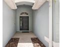 Covered entryway featuring a black front door with decorative window and brick flooring at 2910 Red Coat Cir, Brandon, FL 33511