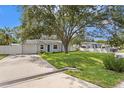 Charming single-story home featuring a well-manicured lawn and a blue front door under the shade of a mature tree at 4717 W Anita Blvd, Tampa, FL 33611
