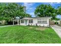 Charming single-story home featuring a carport, light blue door, and a lush front lawn at 517 Fairhope Dr, Apollo Beach, FL 33572