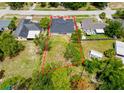 Aerial view of property featuring a lawn and delineated property line surrounded by lush trees at 5352 Lowell Ave, Spring Hill, FL 34609