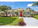 Charming home with stone accents, well-maintained lawn, and a vibrant red front door at 6084 71St N Ave, Pinellas Park, FL 33781