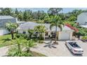 Stunning aerial view showcasing a lovely single story home with a brick driveway and lush tropical landscaping at 751 Bayshore Dr, Tarpon Springs, FL 34689
