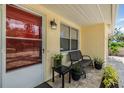 Close-up of charming porch area featuring a bench, plants, and an outdoor light fixture at 751 Bayshore Dr, Tarpon Springs, FL 34689
