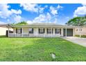 Inviting single-story home featuring a well kept lawn, white picket fence, and a one car garage at 7841 Royal Stewart Dr, New Port Richey, FL 34653