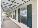 View of an open porch lined with closed shutters and an outside dining set at 7841 Royal Stewart Dr, New Port Richey, FL 34653