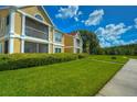 Beautiful condo exterior with lush green lawn, manicured bushes, and large screened-in patios on a sunny day at 9481 Highland Oak Dr # 1506, Tampa, FL 33647