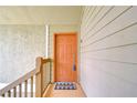 Charming, covered front door entrance with a welcoming mat and neutral siding at 9481 Highland Oak Dr # 1506, Tampa, FL 33647