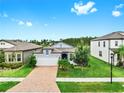 Inviting single-story home with brick driveway, lush green lawn, and a neatly landscaped front yard at 10842 Rolling Moss Rd, Tampa, FL 33647