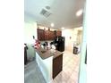Efficient kitchen featuring dark wood cabinets, modern appliances, and a convenient breakfast bar for casual dining at 11309 Villas On The Green Dr, Riverview, FL 33579