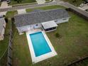Aerial view of a private backyard featuring a sparkling in-ground pool, screened-in patio, and lush green grass at 123 Jeffrey Dr, Brandon, FL 33511
