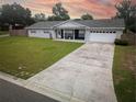 Charming single story home featuring manicured lawn, stone details, attached garage, and a long concrete driveway at 123 Jeffrey Dr, Brandon, FL 33511