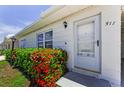 Inviting home entrance with colorful landscaping, white door, and covered carport at 12400 Park Blvd # 311, Seminole, FL 33772