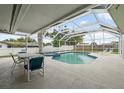 Inviting screened-in pool area with a table, chairs and lounge furniture for outdoor relaxation at 13986 Bonnie Brae Dr, Largo, FL 33774