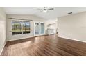 Spacious living room with wood floors, window, glass door, and a bar area at 1421 Vinetree Dr, Brandon, FL 33510