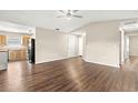 Open-concept living room with wood floors flowing into the kitchen with stainless steel appliances at 1421 Vinetree Dr, Brandon, FL 33510