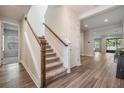Inviting foyer with wood-look flooring, carpeted stairs, and neutral paint colors at 14626 Horse Trot Rd, Lithia, FL 33547