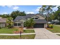 Two-story house with a well-manicured lawn, black shingle roof, two car garage, and mature landscaping at 15846 Glenarn Dr, Tampa, FL 33618