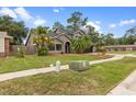 Charming two-story house with a lush green lawn, mature palms, black shingle roof, and two car garage at 15846 Glenarn Dr, Tampa, FL 33618