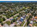 An aerial view showcasing a neighborhood with tree-lined streets, various home styles, and proximity to recreational areas and waterways at 1801 52Nd S St, Gulfport, FL 33707