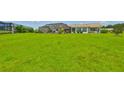 Expansive green backyard with a view of the screened-in lanai at 1811 Milford Cir, Sun City Center, FL 33573