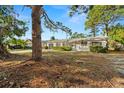 Cozy one-story home with classic shutters, set against a backdrop of mature trees and lush foliage at 2145 68 S Ave, St Petersburg, FL 33712
