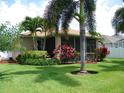 Backyard featuring a covered lanai, vibrant landscaping, and lush green grass at 27810 Sky Lake Cir, Wesley Chapel, FL 33544