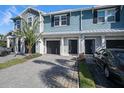 Charming townhome featuring a well-maintained front yard, paved driveway, and attached garage at 2919 Grand Kemerton Pl, Tampa, FL 33618