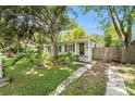 Single-story home with mature landscaping, stone walkway, and driveway with a privacy fence at 3709 W San Pedro St, Tampa, FL 33629