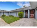Light gray condo exterior featuring a well-manicured lawn and charming shrubbery at 4160 Fruitville Rd # 77, Sarasota, FL 34232