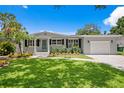 Charming home featuring a well-maintained lawn, lovely landscaping, and a neatly paved driveway at 5107 W Platt St, Tampa, FL 33609