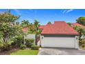 Beautiful home featuring a vibrant red tile roof, white garage door, and lush landscaping at 780 Sarabay Rd # 16, Osprey, FL 34229