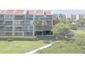 Exterior view of waterfront condos with balconies, well-kept landscaping, and a sidewalk at 7907 Sailboat Key S Blvd # 108, South Pasadena, FL 33707