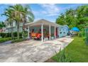 View of the covered carport with a vintage truck, lush green lawn, and freshly painted exterior at 1042 S Sterling Ave, Tampa, FL 33629