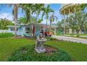 Quaint home featuring a covered carport, manicured lawn, and mature palm trees for a tropical feel at 1042 S Sterling Ave, Tampa, FL 33629