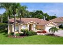 Well-manicured front yard with mature landscaping complementing this bright home at 1358 Forestedge Blvd, Oldsmar, FL 34677