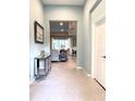 Welcoming foyer with stylish mirror cabinet, leading to the living and dining areas at 16413 Rivers Reach Blvd, Parrish, FL 34219