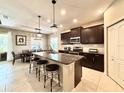 Modern kitchen featuring dark wood cabinets, granite countertops, and stainless steel appliances at 16413 Rivers Reach Blvd, Parrish, FL 34219