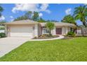 Charming single-story home with a well-manicured lawn and a two-car garage at 18504 Putters Pl, Tampa, FL 33647