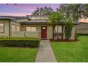 Charming single-story home with vibrant landscaping and a welcoming red front door at 200 Gretchen Ct, Oldsmar, FL 34677