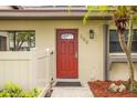 Close-up of front door with red finish, address number, and small palm trees at 200 Gretchen Ct, Oldsmar, FL 34677