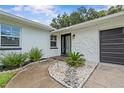 Inviting front entrance with decorative stone landscaping and a modern glass-paneled door at 210 Lake Hobbs Rd, Lutz, FL 33548
