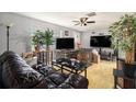 Inviting living room with hardwood floors, a ceiling fan, and bright natural lighting from the windows at 2149 Dixie Garden Loop, Holiday, FL 34690