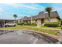 Exterior view of townhouse complex with covered parking, distinctive roofline, and well-maintained landscaping at 2206 Cordova Grn # 2206, Seminole, FL 33777