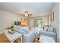 Inviting living room with neutral tones, comfortable seating, ceiling fan, and sliding glass doors to outdoor space at 2206 Cordova Grn # 2206, Seminole, FL 33777